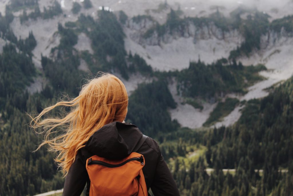 femme blonde regardant l'horizon montagneux